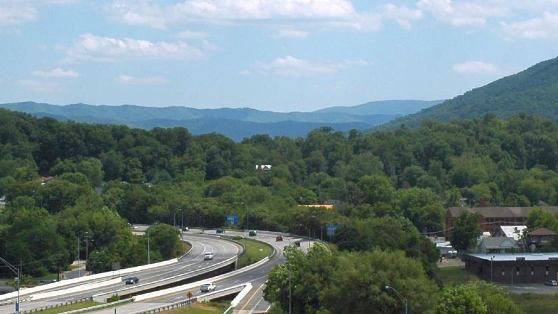 A train traveling down a road in a mountainous area