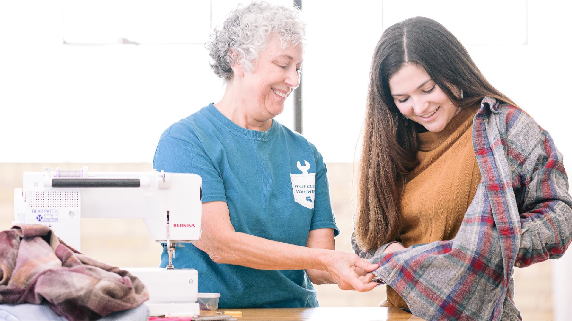 Image of two women looking at a shirt they mended