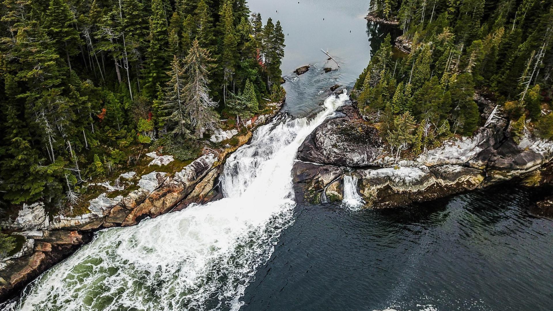 Rushing river between two tree-covered land masses