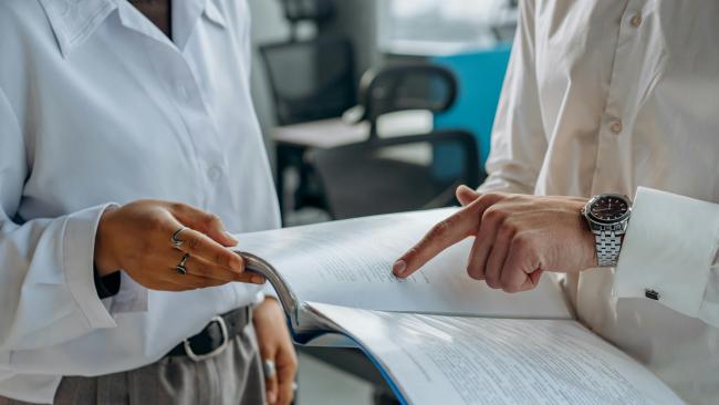 Two people reviewing a document in an office setting.